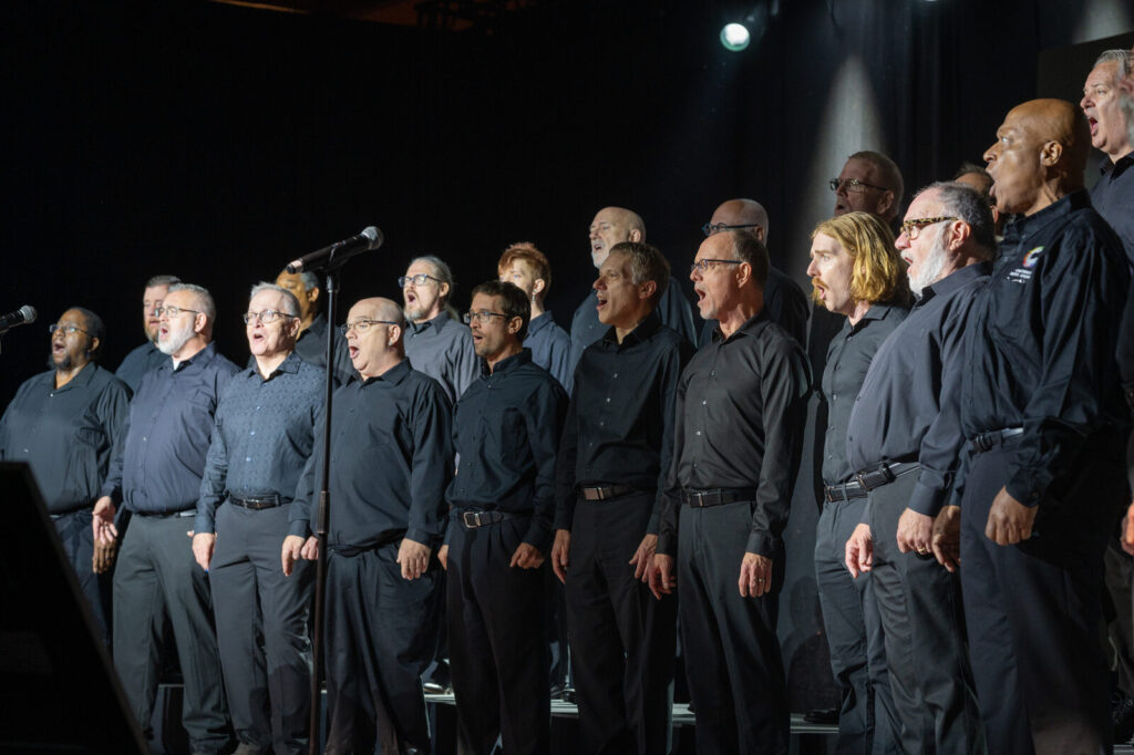 Men’s chorus performing on stage at the Zeno Group P&G GABLE event, Hard Rock Casino Cincinnati