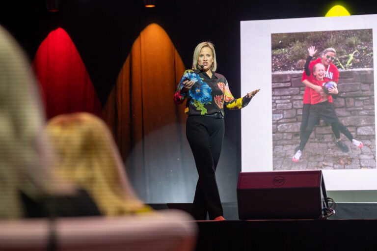 Speaker presenting with a photo on screen at the Zeno Group P&G GABLE event, Hard Rock Casino Cincinnati