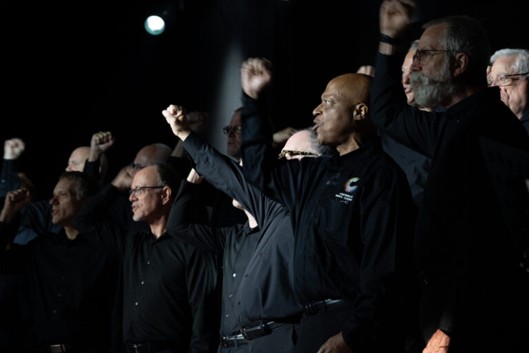 Chorus members raising fists on stage at the Zeno Group P&G GABLE event, Hard Rock Casino Cincinnati