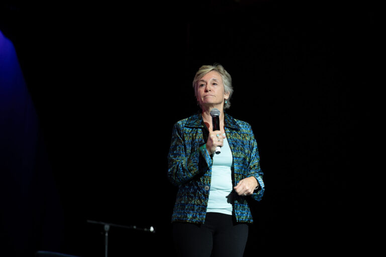 Speaker with a microphone on stage at the Zeno Group P&G GABLE event, Hard Rock Casino Cincinnati